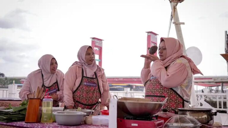 Ba phụ nữ chủ hộ kinh doanh siêu nhỏ (UMKM) tham gia hoạt động nấu ăn trong chương trình “Cerita Rasa” của Amartha tại Palembang (Nam Sumatra, Indonesia), nhằm tôn vinh ẩm thực địa phương và vai trò kinh tế của phụ nữ. Ảnh: chụp màn hình từ Sumsel.Tribunnews.com.