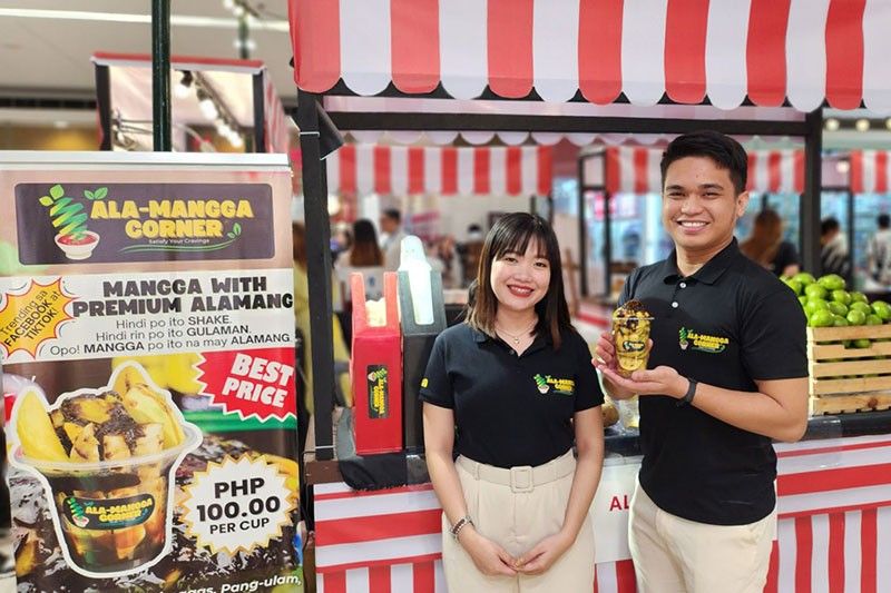 Đại diện một gian hàng MSME giới thiệu sản phẩm đồ ăn vặt tại khu sự kiện trong trung tâm thương mại SM ở Philippines, minh họa các hoạt động “pop-up” mà SM Supermalls cho biết sẽ tiếp tục mở rộng trong năm 2026 để hỗ trợ doanh nghiệp nhỏ tiếp cận khách hàng. Ảnh: chụp lại từ Philstar