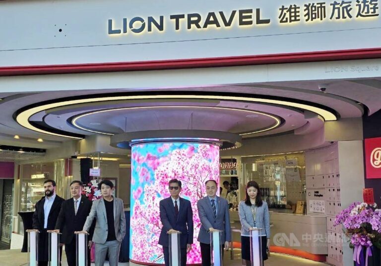 Lối vào điểm giao dịch của Lion Travel (雄獅旅遊) tại Đài Bắc, nơi diễn ra nghi thức khởi động với các đại biểu đứng cạnh các trụ kích hoạt trước cửa. (Ảnh chụp lại từ: Central News Agency – CNA)