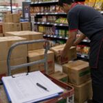 Nhân viên kho chuẩn bị thùng thực phẩm đóng gói cho xe giao hàng bán lẻ. Ảnh minh họa tin tức.