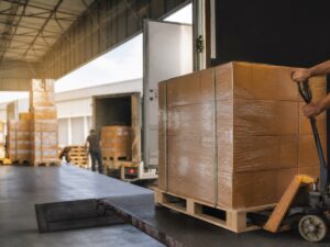 Khu giao nhận hàng hóa nội địa với pallet và xe tải không thương hiệu. Ảnh minh họa tin tức.