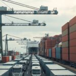 Cảng container hàng hóa với cần cẩu xếp dỡ container trên tàu vận tải lớn dưới bầu trời nhiều mây, chủ đề thương mại FTA Thái Lan